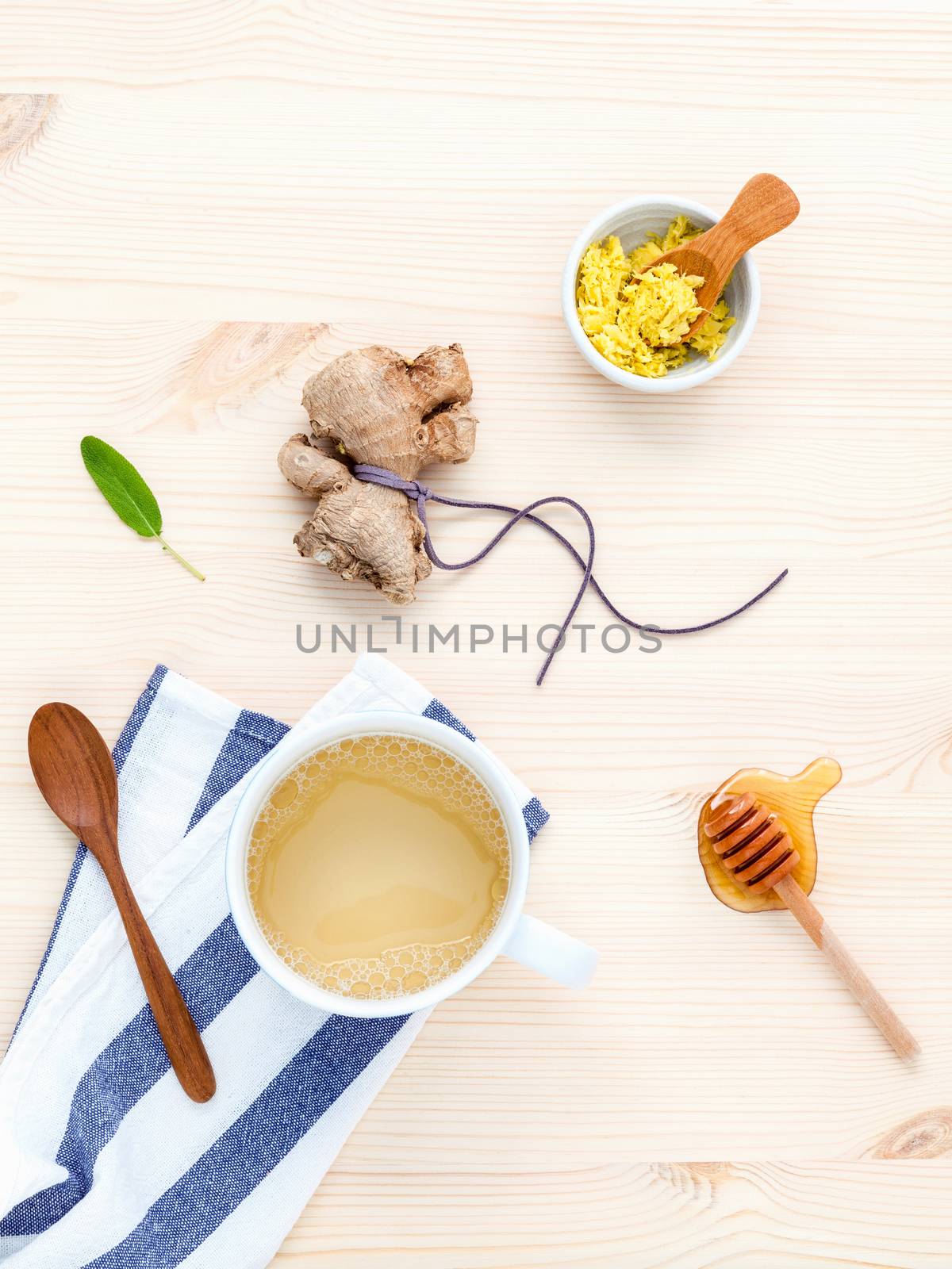 The cup of ginger tea with ginger roots , honey and mint on rustic wooden table.