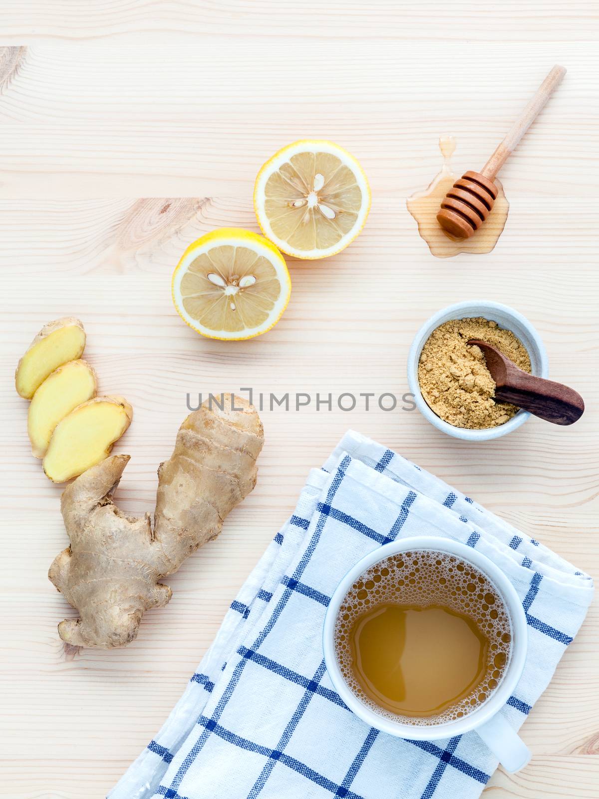 The cup of ginger tea with ginger roots , ginger powder ,lemon and honey  on rustic wooden table.