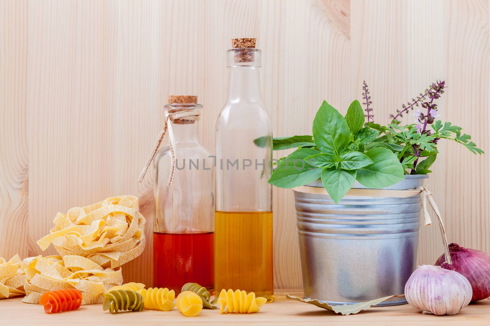 Italian food concept pasta with vegetables olive oil  with spices herbs sage,parsley holy basil and basil set up with wooden background.