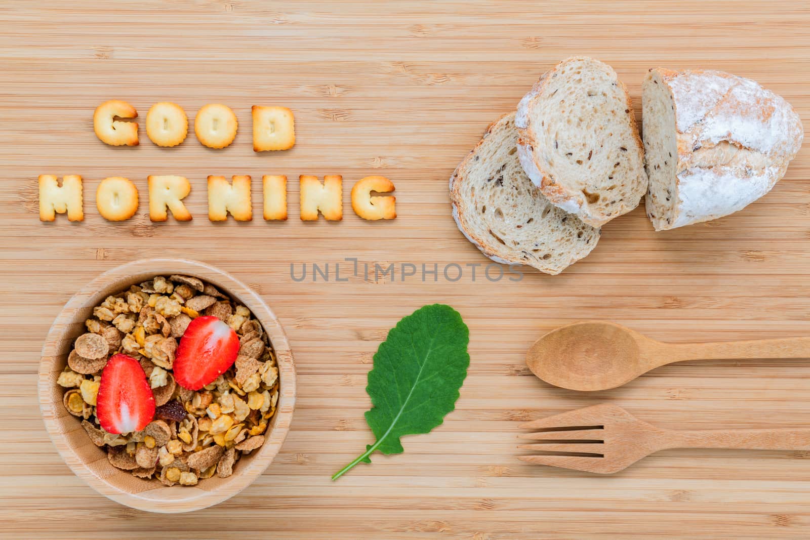 Good morning concept - Cereal in wooden bowl with strawberry and wooden spoon set up on wooden background.