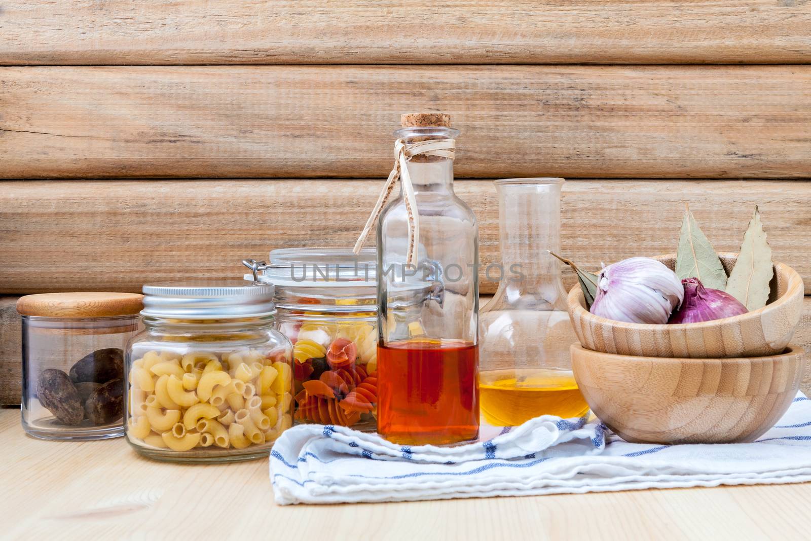 Italian food concept dried pasta with vegetables ,olive oil and spices herbs parsley , basil  and rosemary set up with white cheese on wooden background.