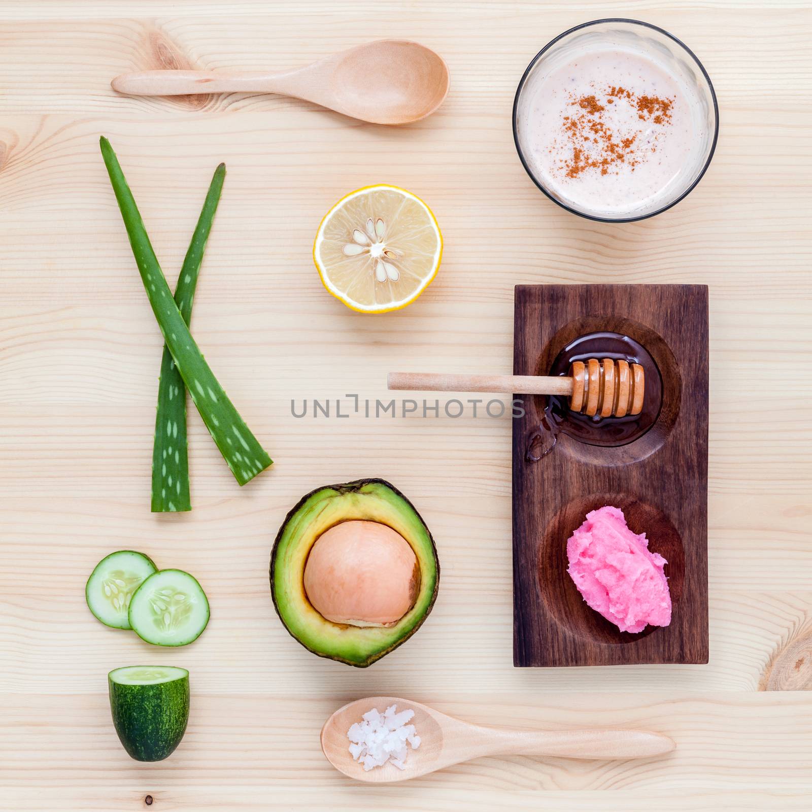 Homemade skin care and body scrub with natural ingredients avocado ,aloe vera ,lemon,cucumber and honey set up on on  wooden background.