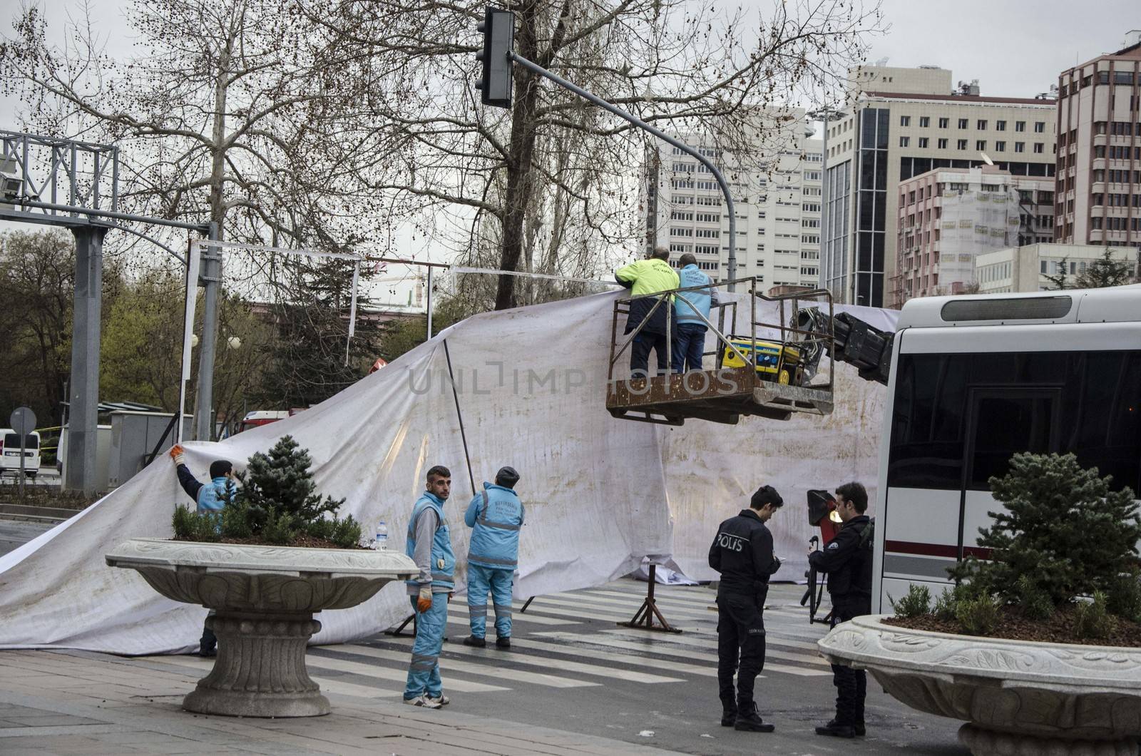 TURKEY, Ankara: Turkish workers erect a white tarpaulin in Guven Park in the Kizilay district, a key transport hub of the Turkish capital city Ankara on March 14, 2016, one day after a car bomb exploded in Ankara  killing at least 32 people and wounding more than 100, according to the health ministry. On February 2016, a bomb attack claimed by a Kurdish militant group on a military convoy in Ankara killed 28 people and wounded dozens more. On October 2015, more than 100 people were killed in a double-suicide bombing at a Kurdish peace rally in Ankara. 