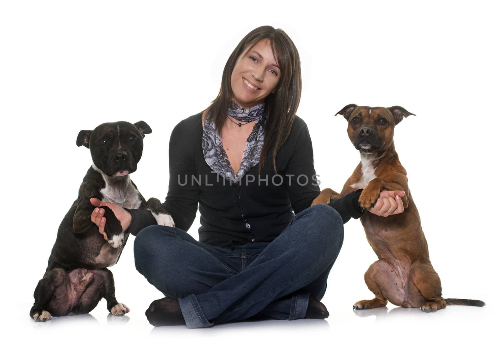 woman and staffordshire bull terrier in front of white background