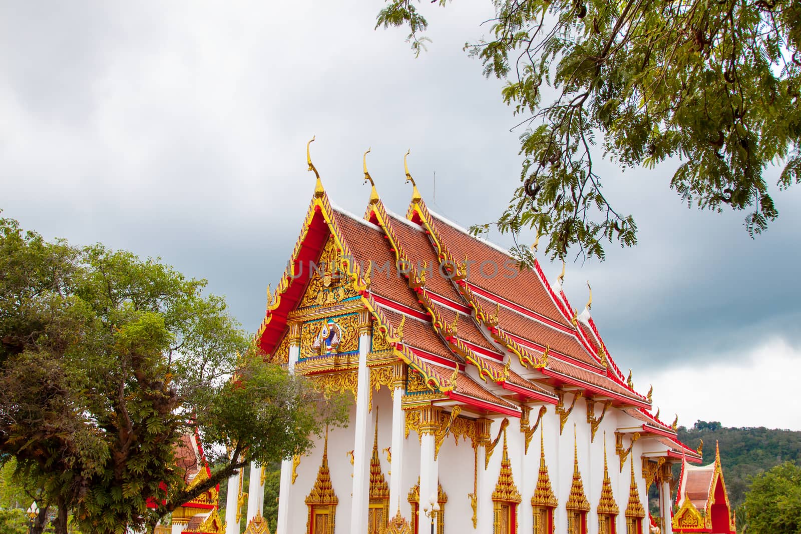 Buddhist asian gold decorated sanctuary on background of cloudy sky