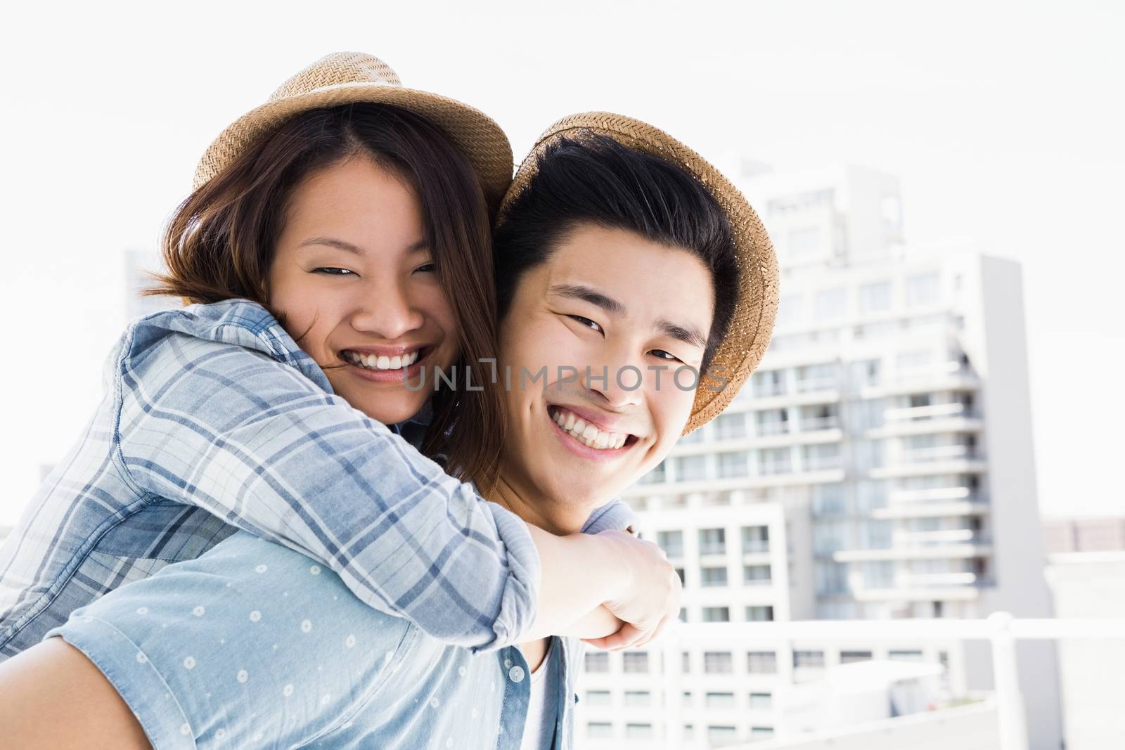 Young man giving a piggyback ride to woman outdoors