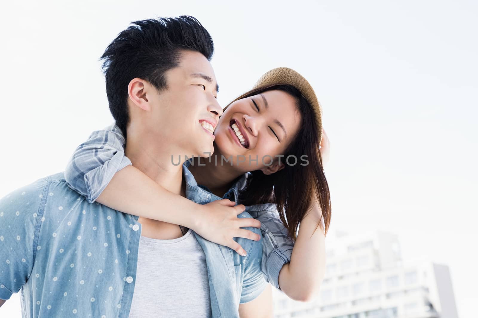 Young man giving a piggyback ride to woman outdoors