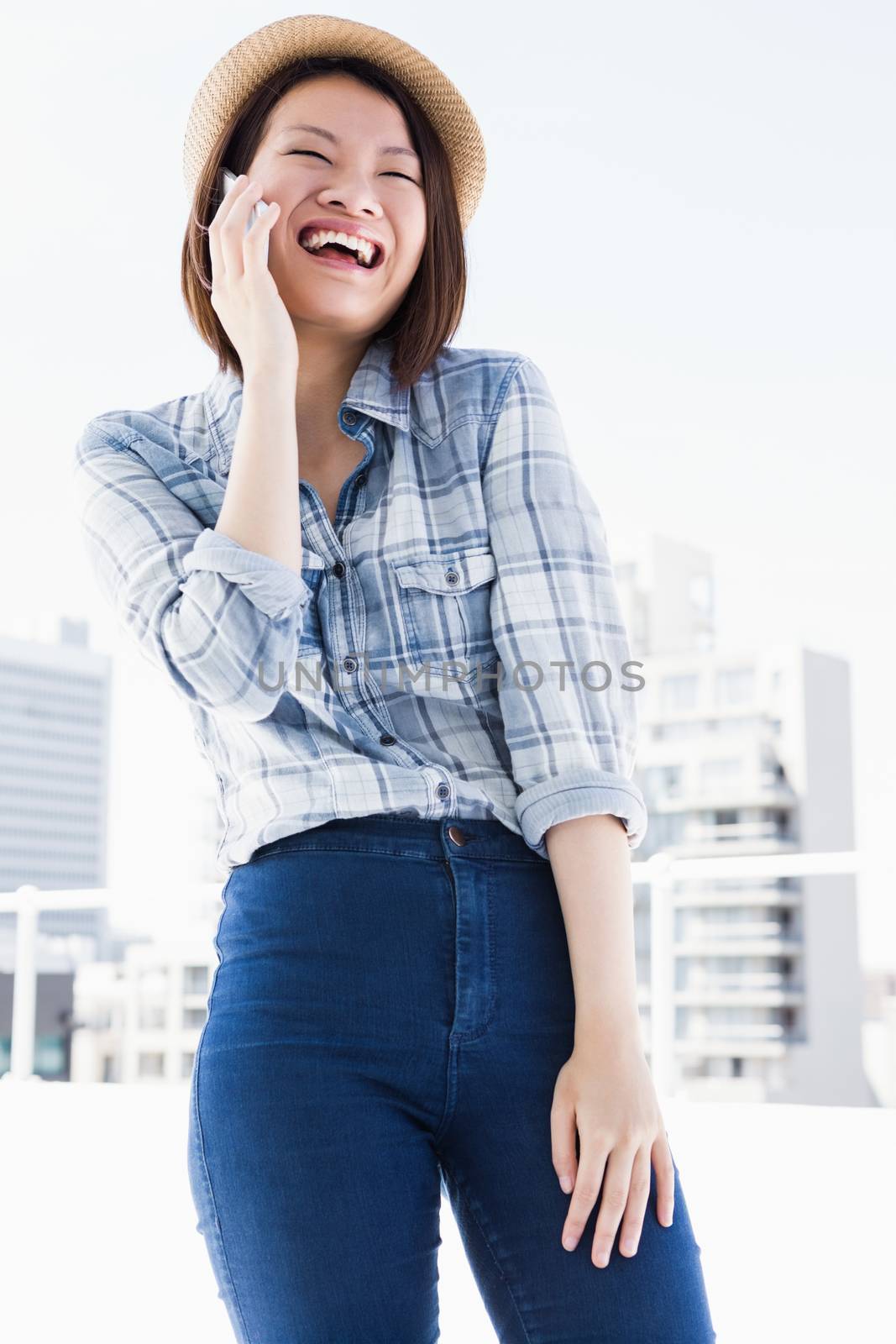 Happy young woman talking on mobile phone by Wavebreakmedia