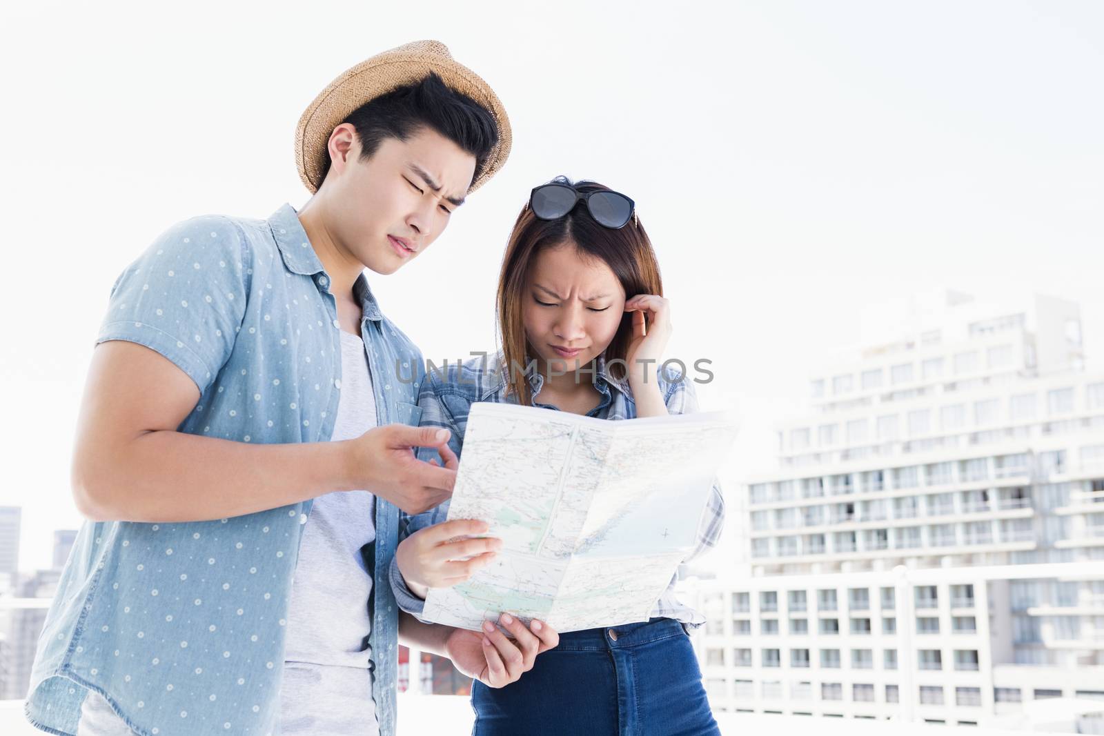 Young couple looking at map for direction outdoors