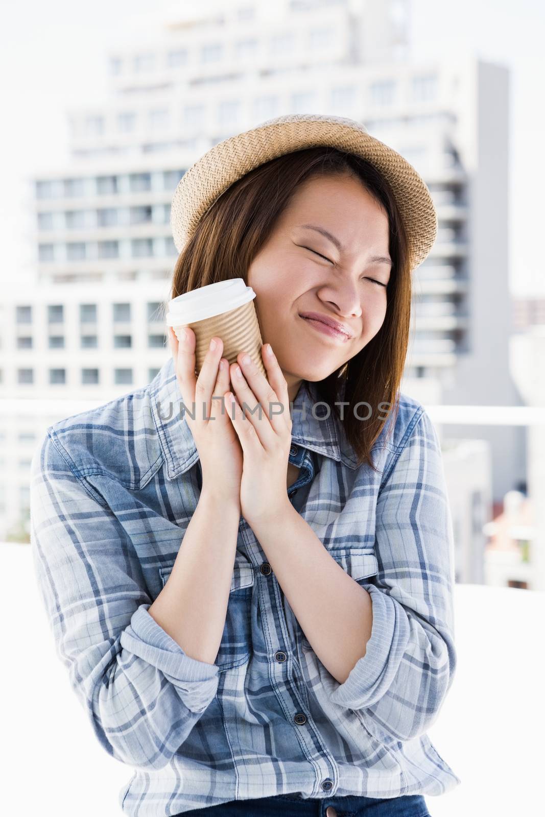 Young woman holding disposable cup by Wavebreakmedia