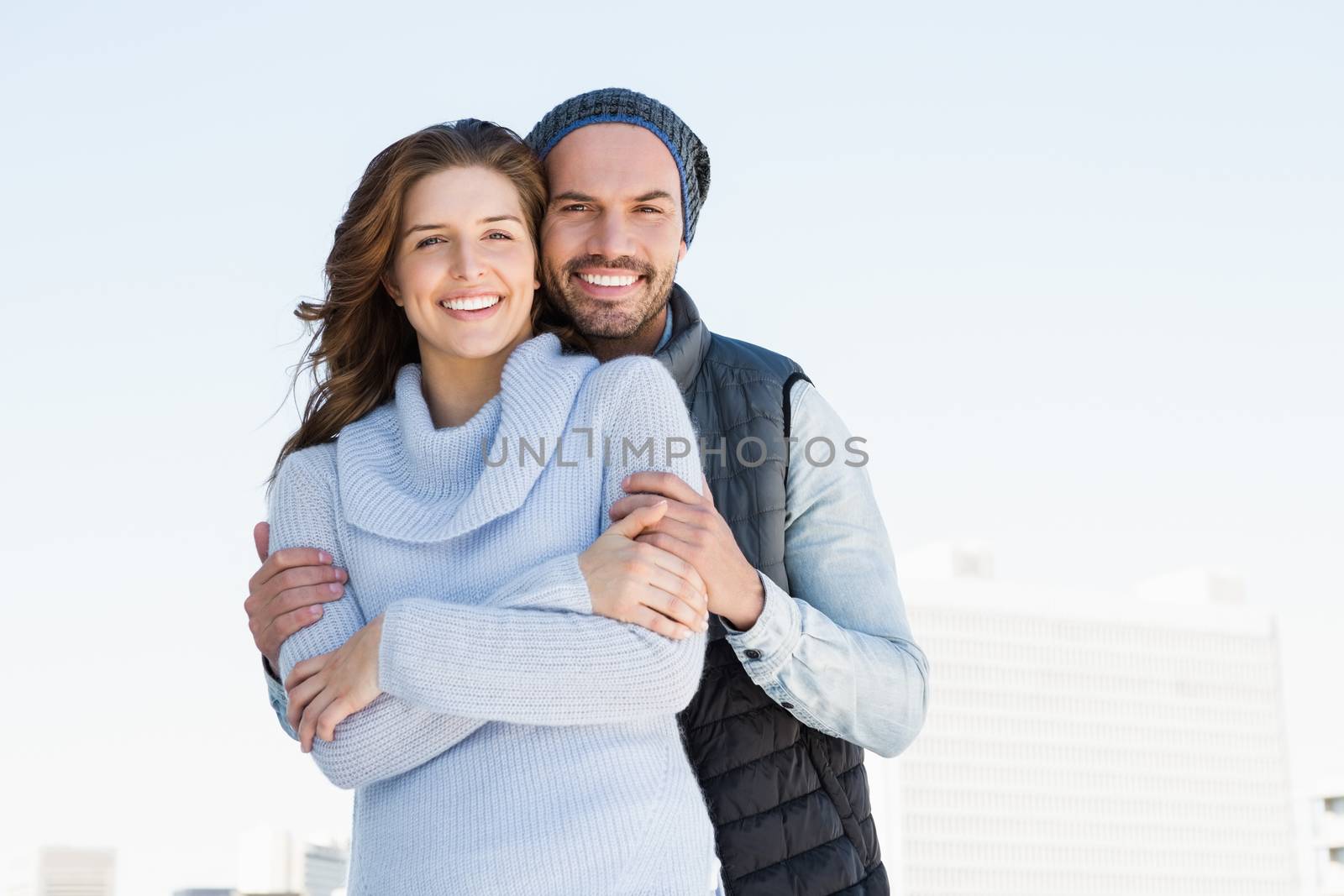 Happy couple embracing each other and smiling outdoors