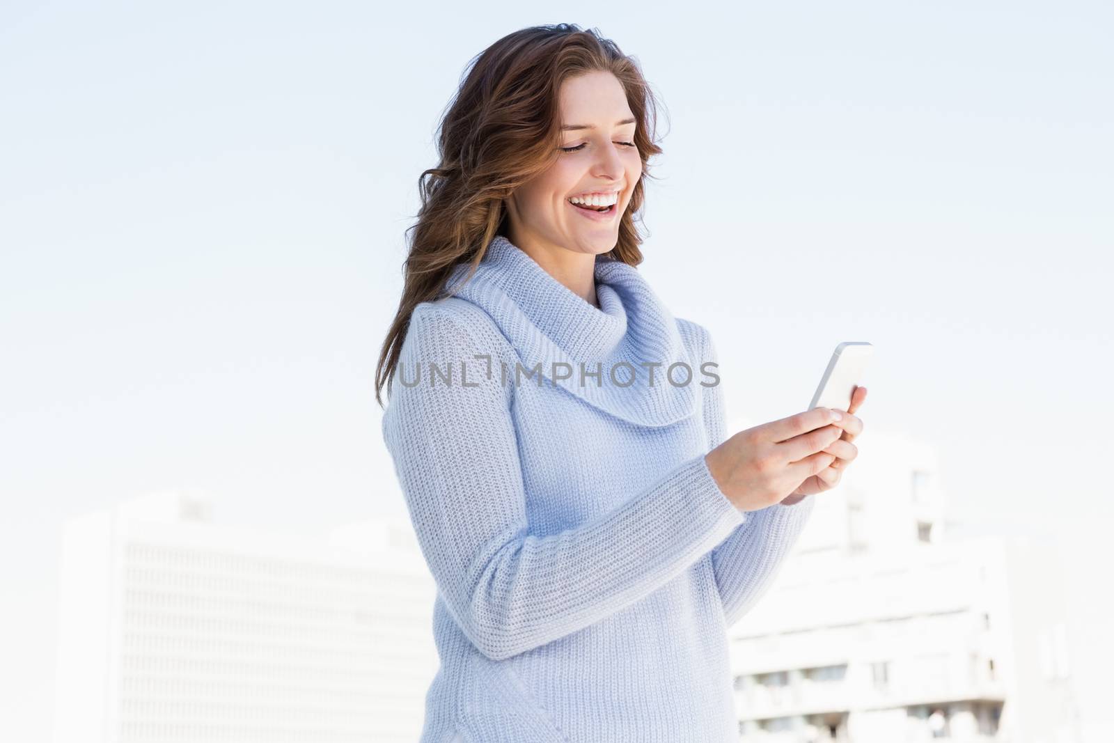 Happy young woman using mobile phone by Wavebreakmedia