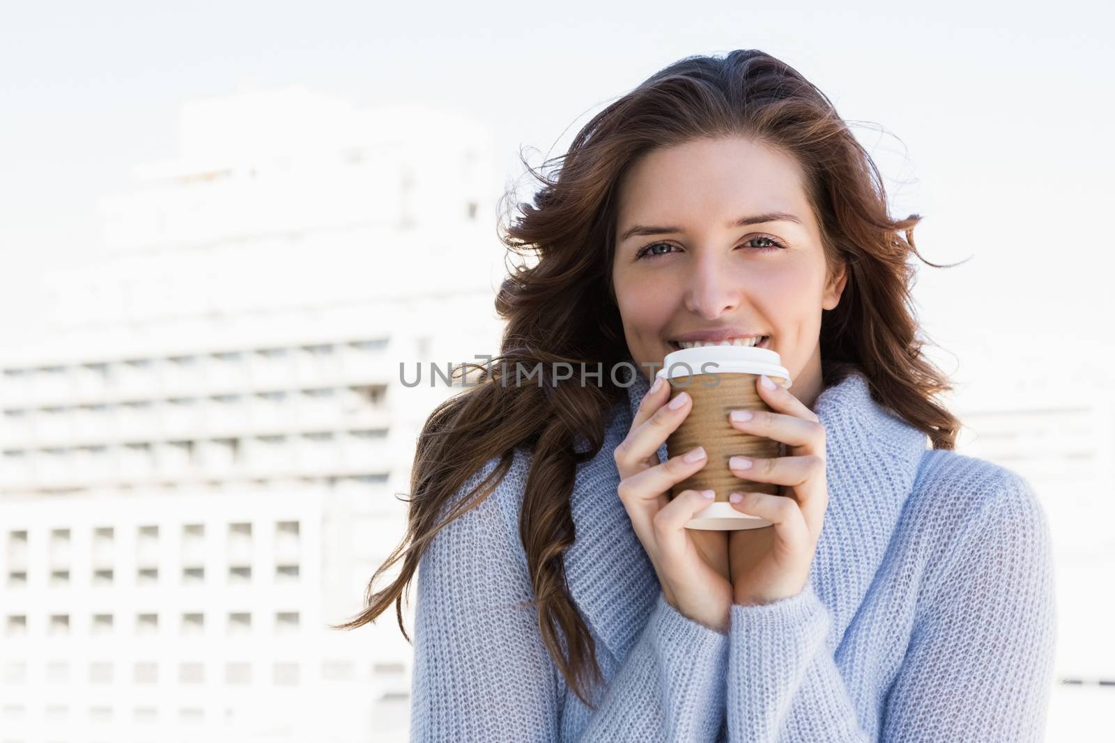 Happy young woman having coffee outdoors