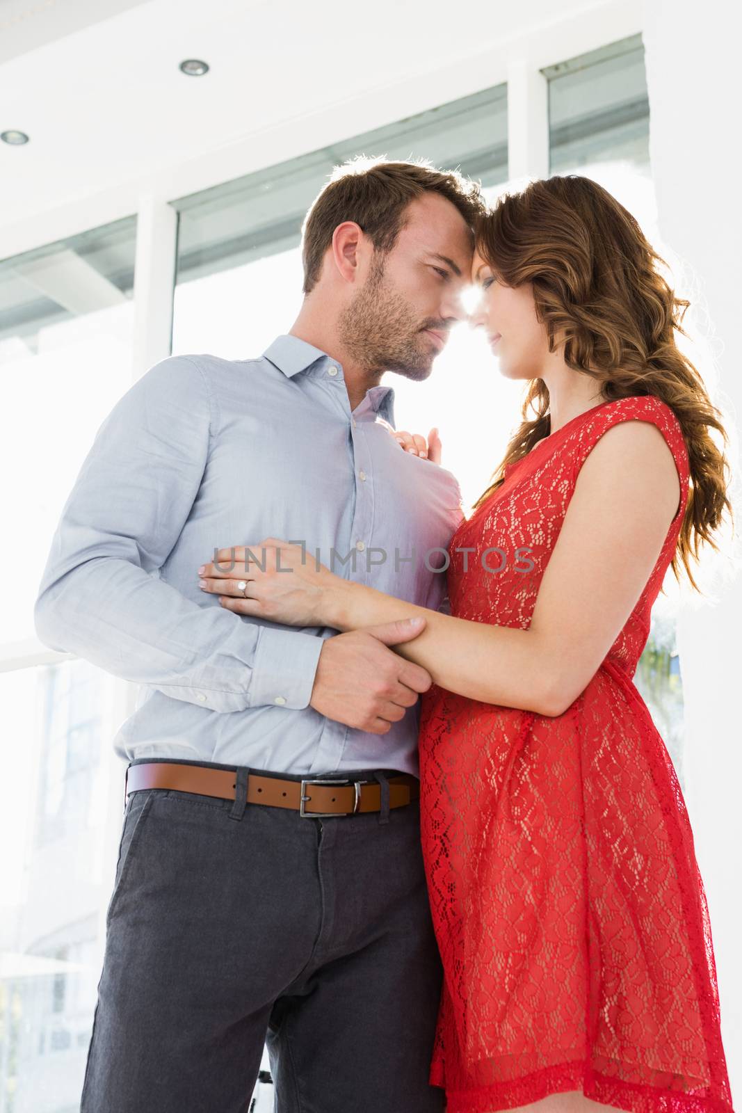 Young couple looking at each other and embracing by Wavebreakmedia