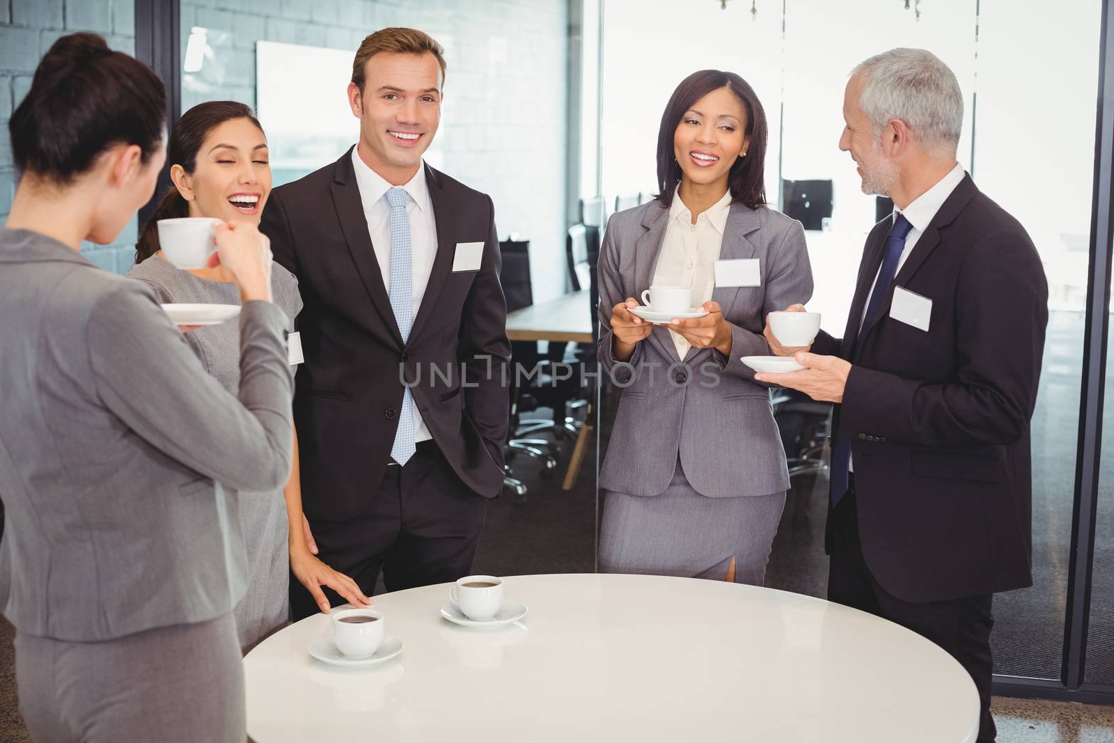 Businesspeople having tea and interacting during breaktime in office