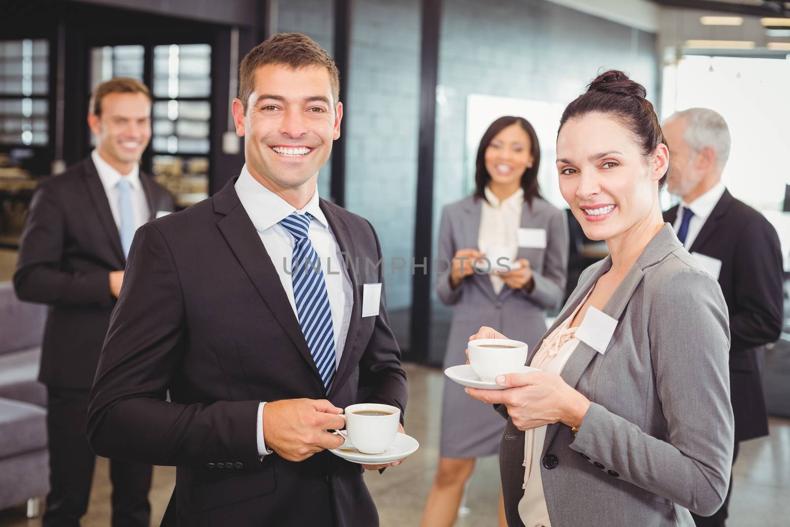 Portrait of businesspeople having tea and interacting during break time in office