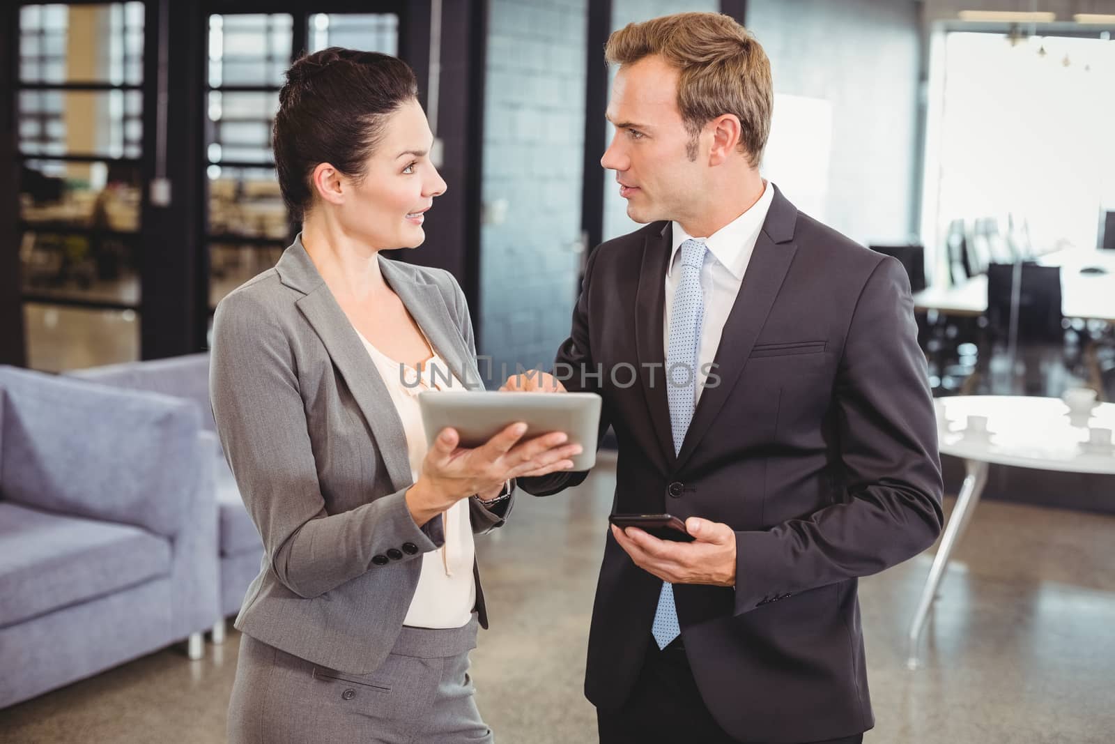Businessman and businesswoman using digital tablet in office