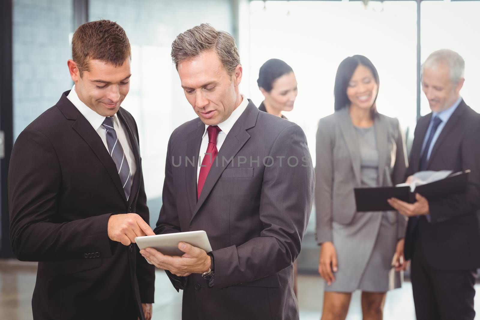 Businessmen using digital tablet in office