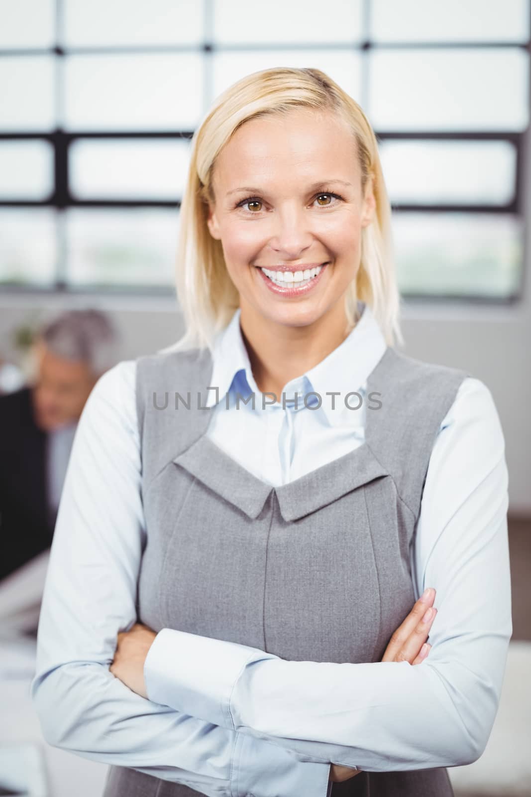 Smiling businesswoman standing in meeting room by Wavebreakmedia