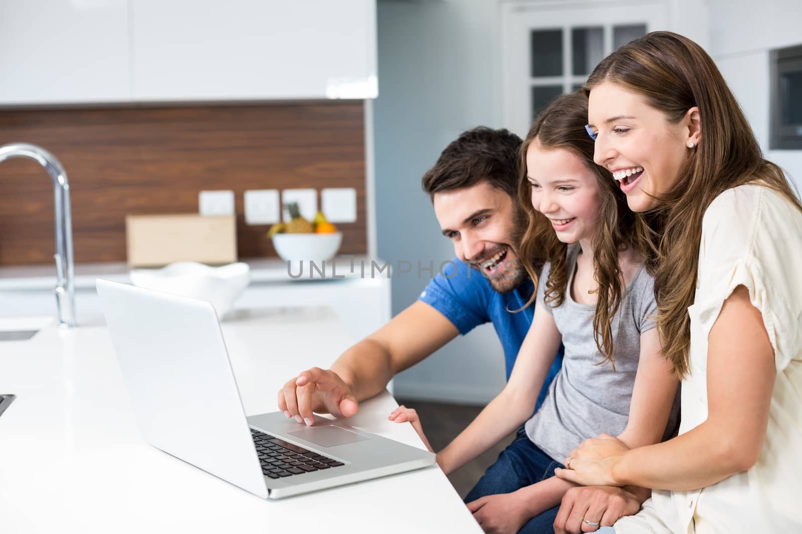 Happy family looking at laptop at home 