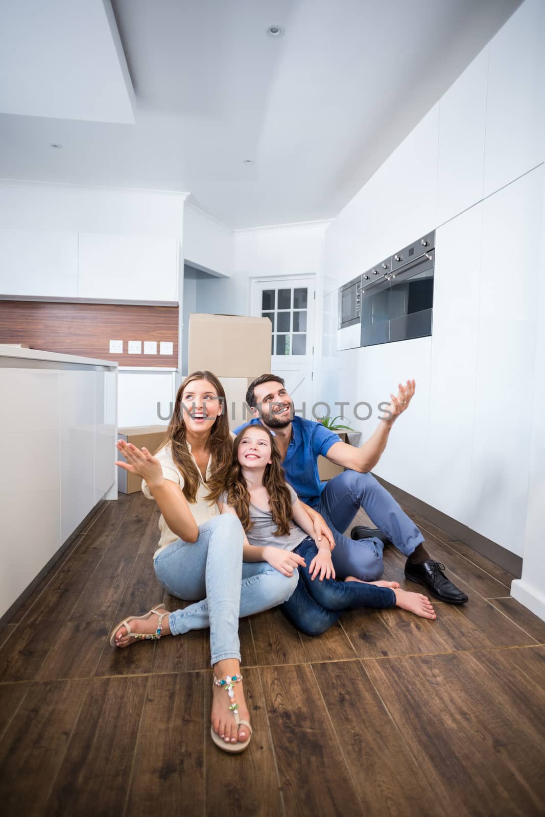 Happy family sitting on floor at home 
