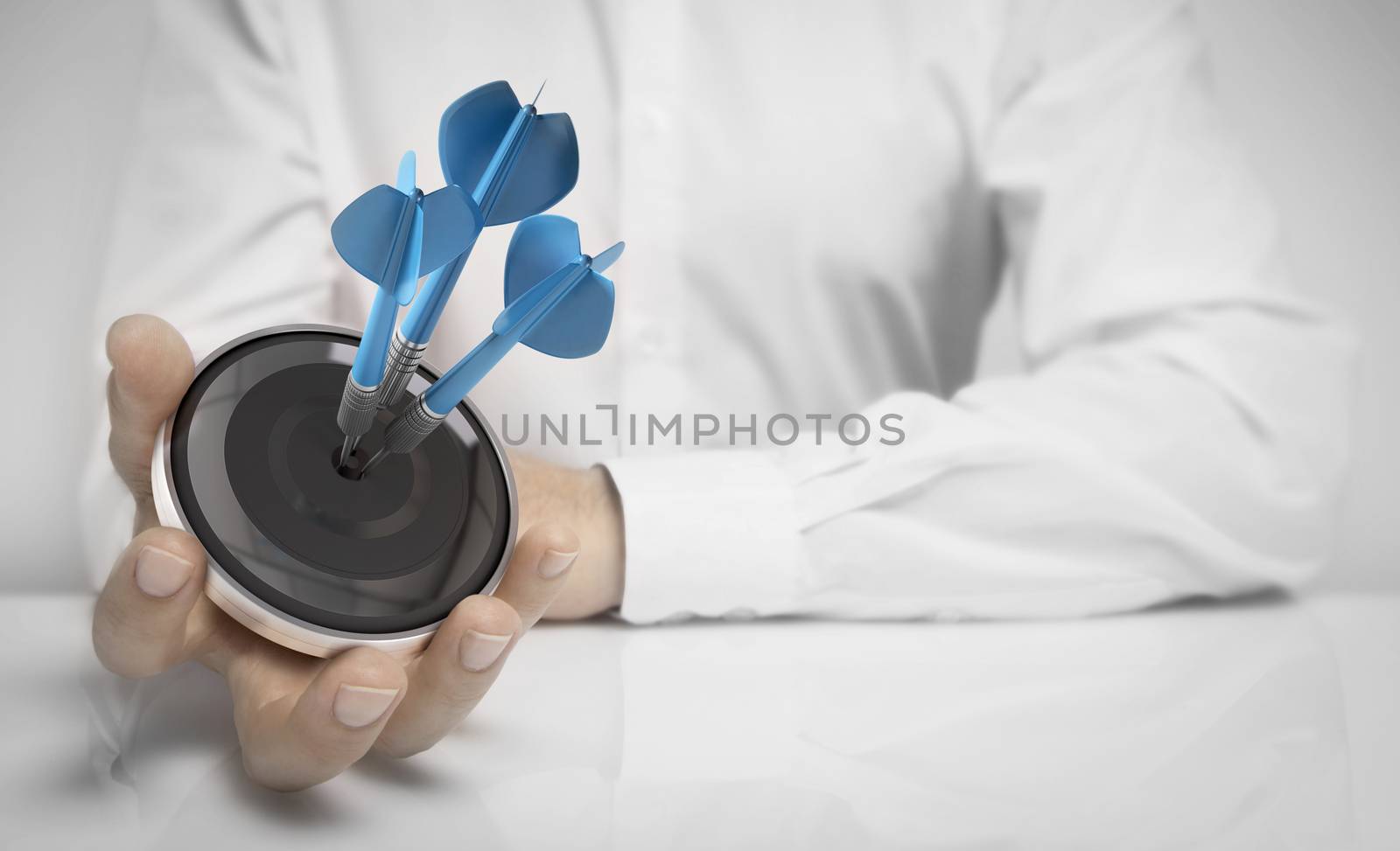 Man hand holding a target with three darts hitting the center over white background. Concept of personal coaching success and objective attained