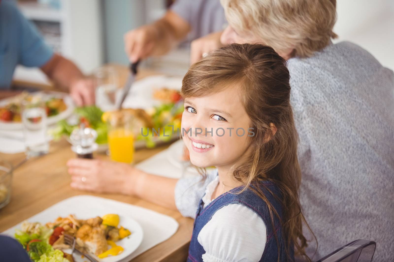 Happy girl having breakfast with family by Wavebreakmedia