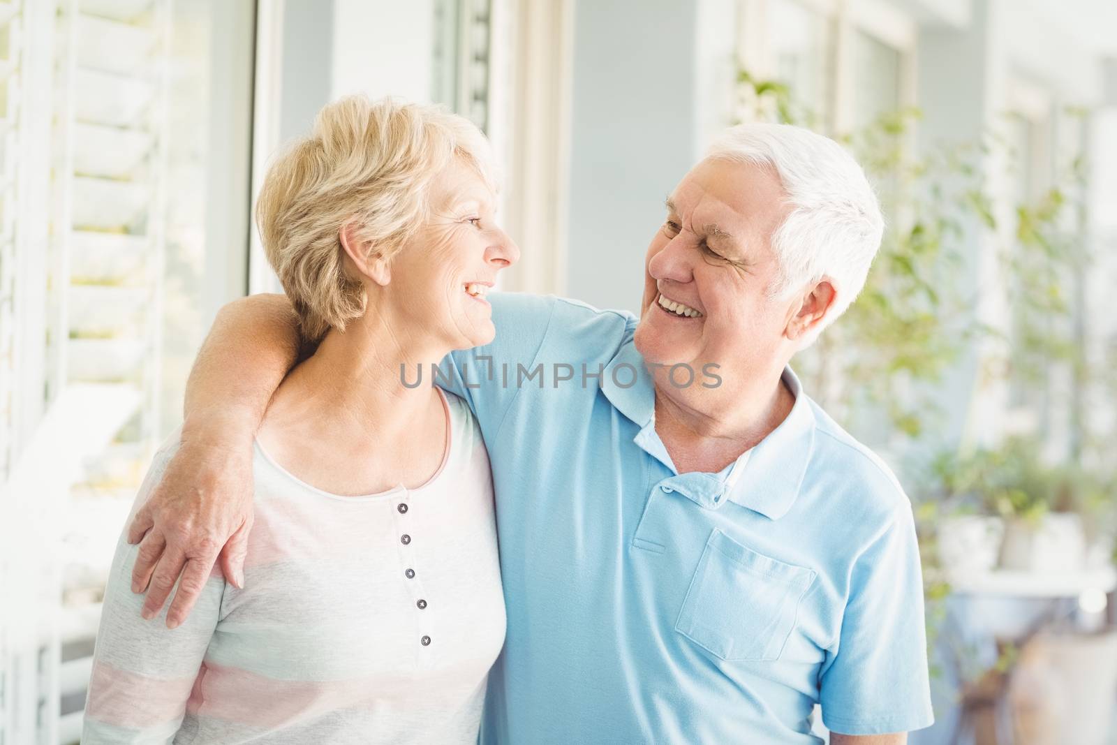 Smiling romantic senior couple at home by Wavebreakmedia
