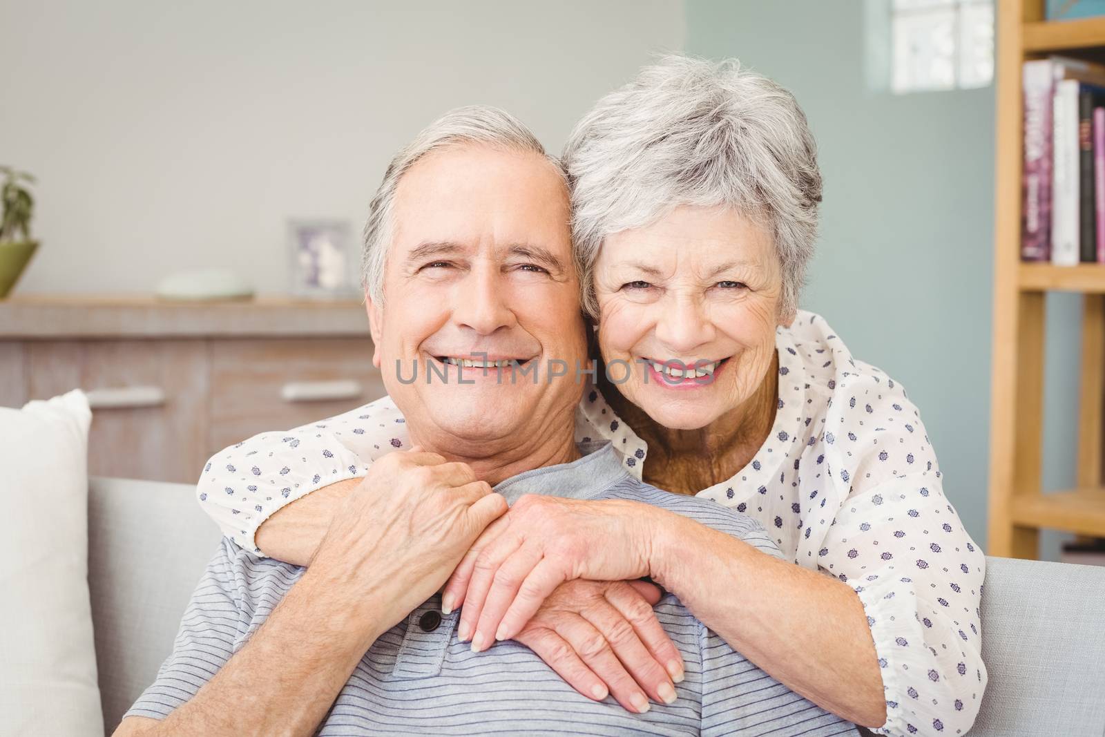 Portrait of romantic senior couple embracing at home