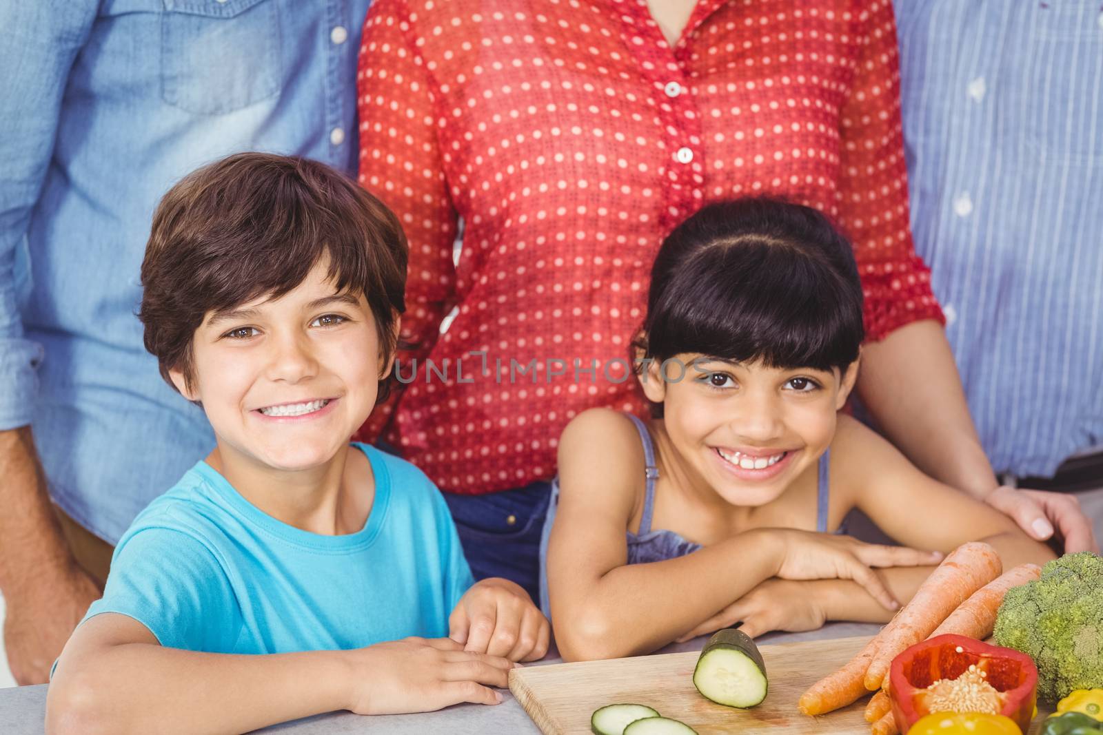 Portrait of siblings with family in kitchen