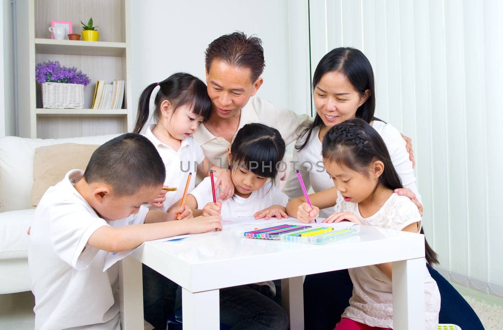 asian family doing school homework at living room