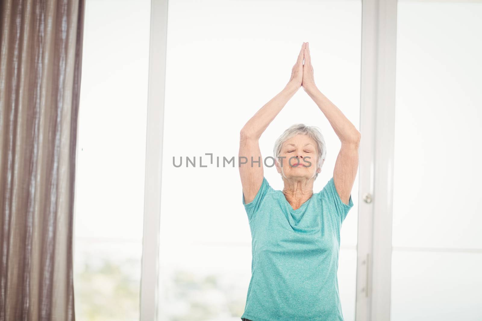 Senior woman performing yoga at home