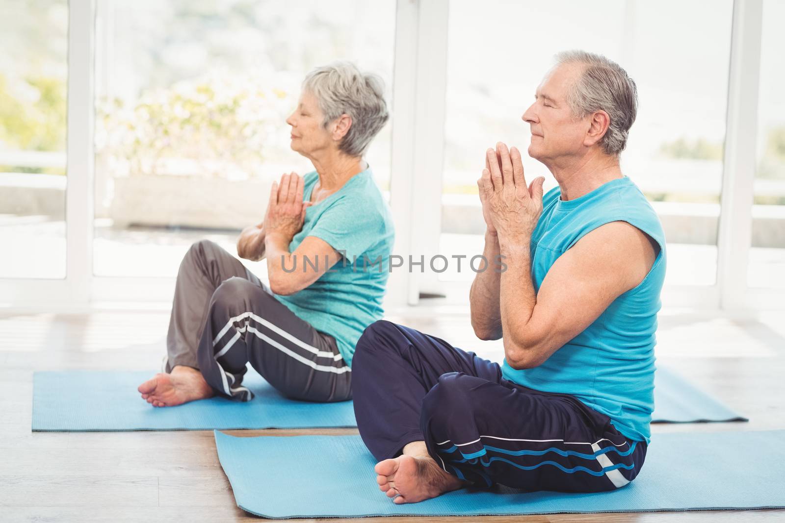Senior couple performing yoga by Wavebreakmedia