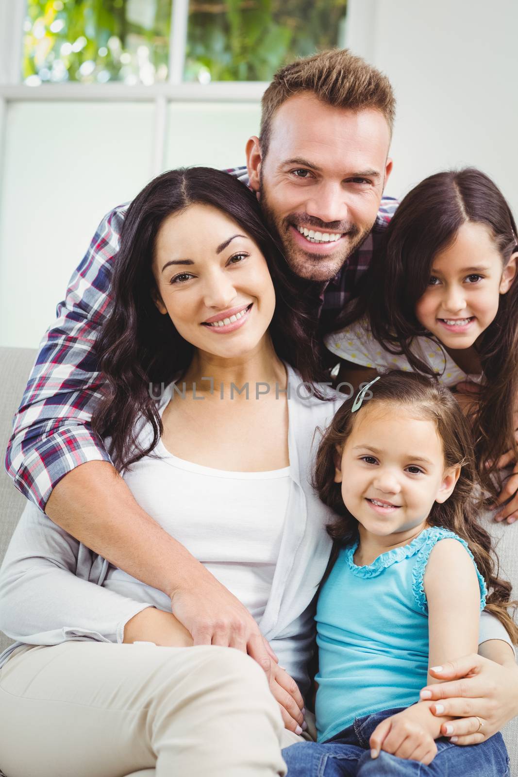 Portrait of smiling family with daughters at home