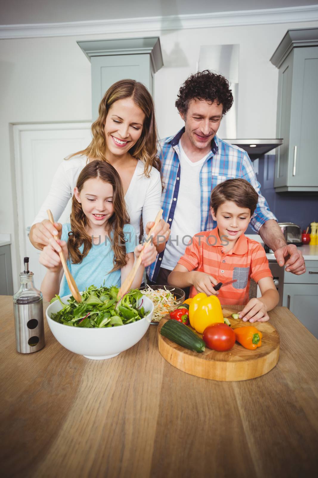Young couple with children in kitchen by Wavebreakmedia