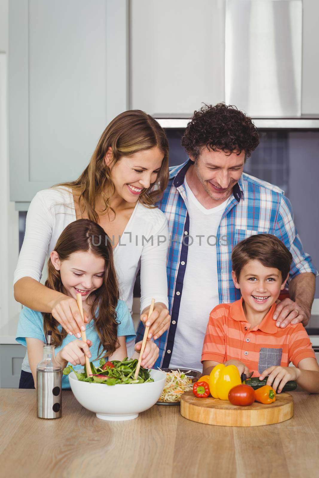 Happy family standing by table in kitchen at home