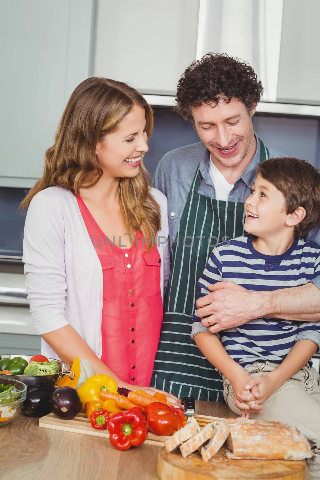 Happy parents with son in kitchen by Wavebreakmedia