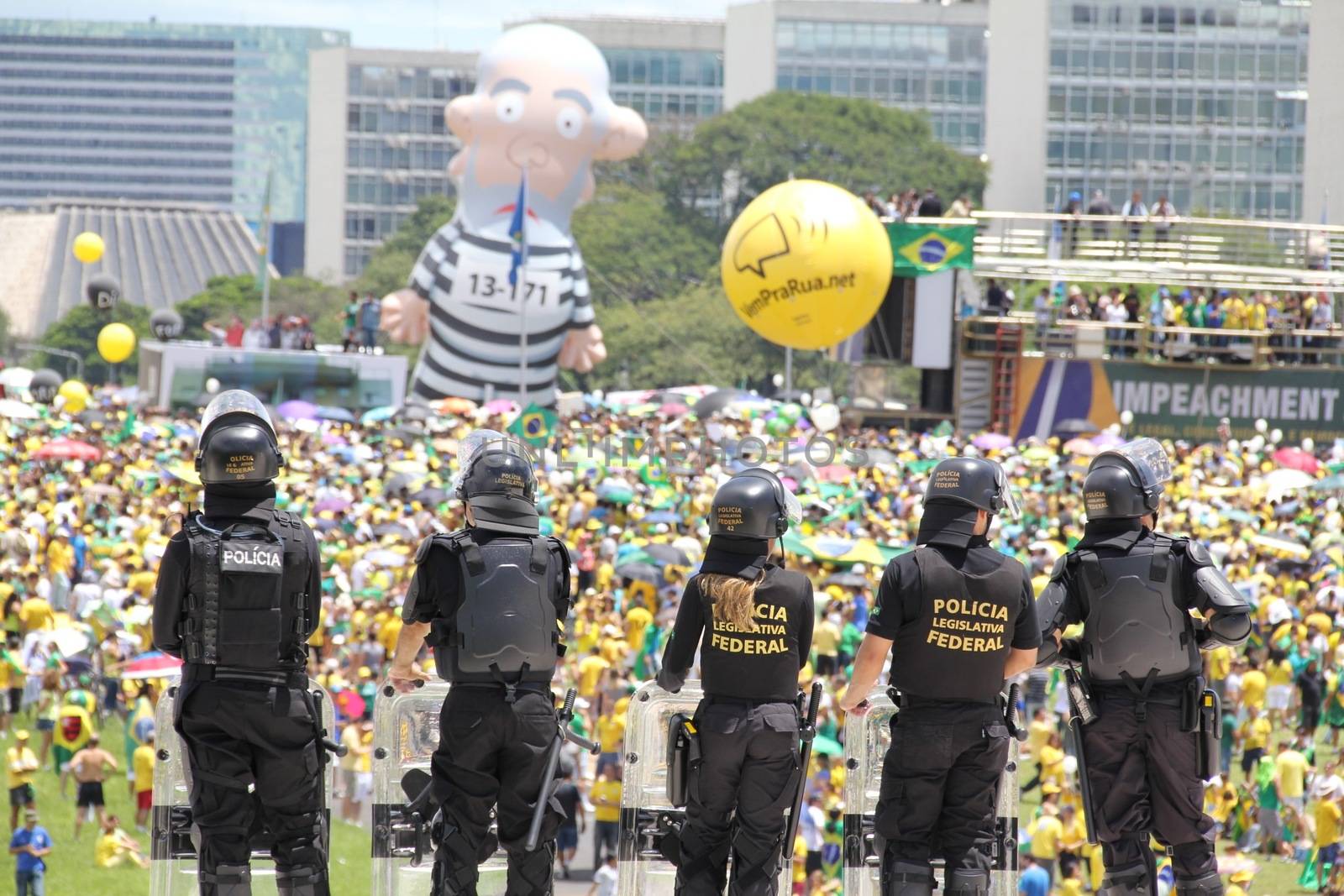 BRAZIL, Brasilia: Riot police officers stand in guard as thousands of anti-government protestors gather on the Praça dos Três Poderes (Three Powers Square), in Brasilia, during a demonstration calling for the removal of President Dilma Rousseff on March 13, 2016 . Demonstrations across the country today called for President Rousseff's exit amidst a massive corruption scandal and a deep economic recession. More than a million Brazilians have joined anti-government rallies across the country, ramping up the pressure on embattled president.