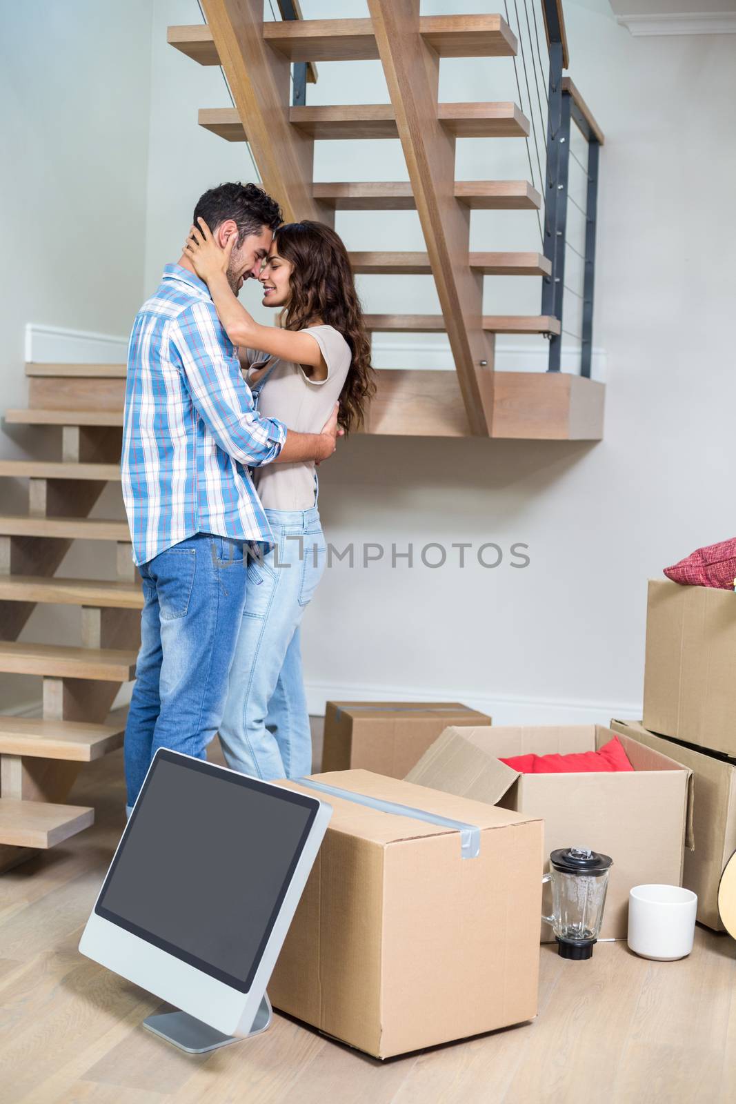 Side view of romantic couple hugging while standing at home