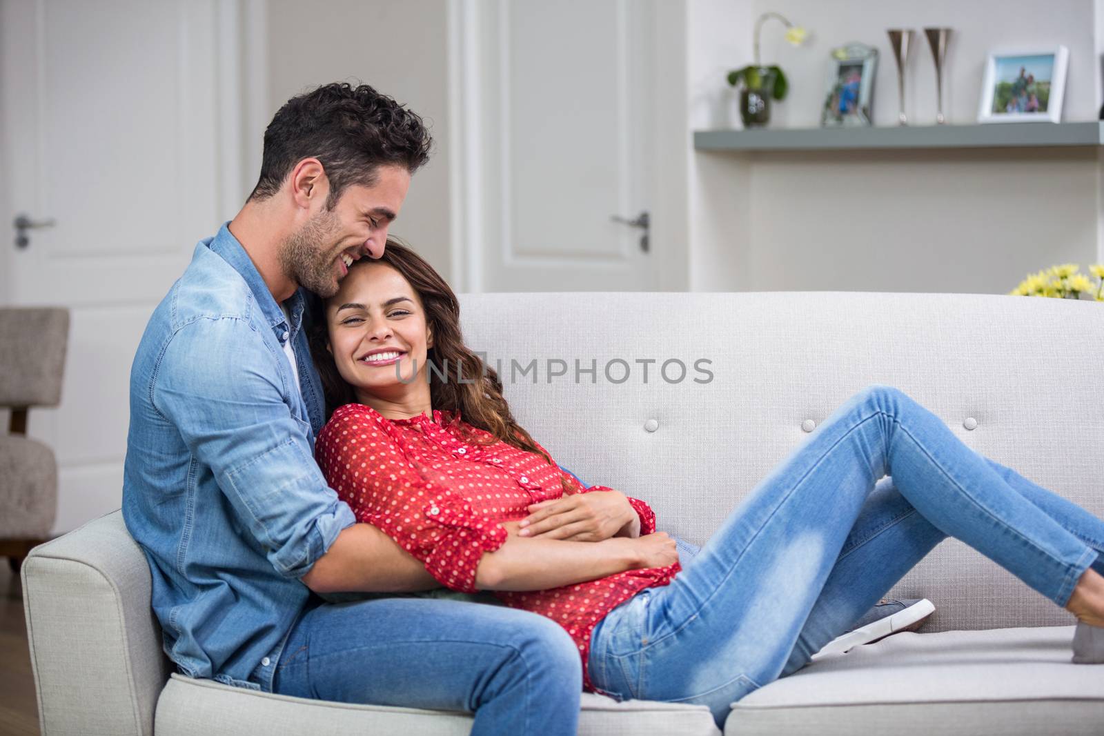  Romantic couple hugging on sofa at home