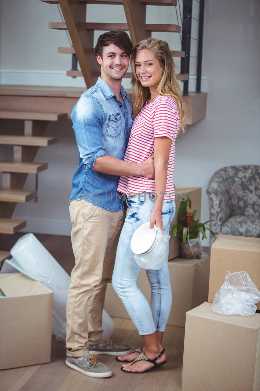 Portrait of smiling romantic couple while standing in new house