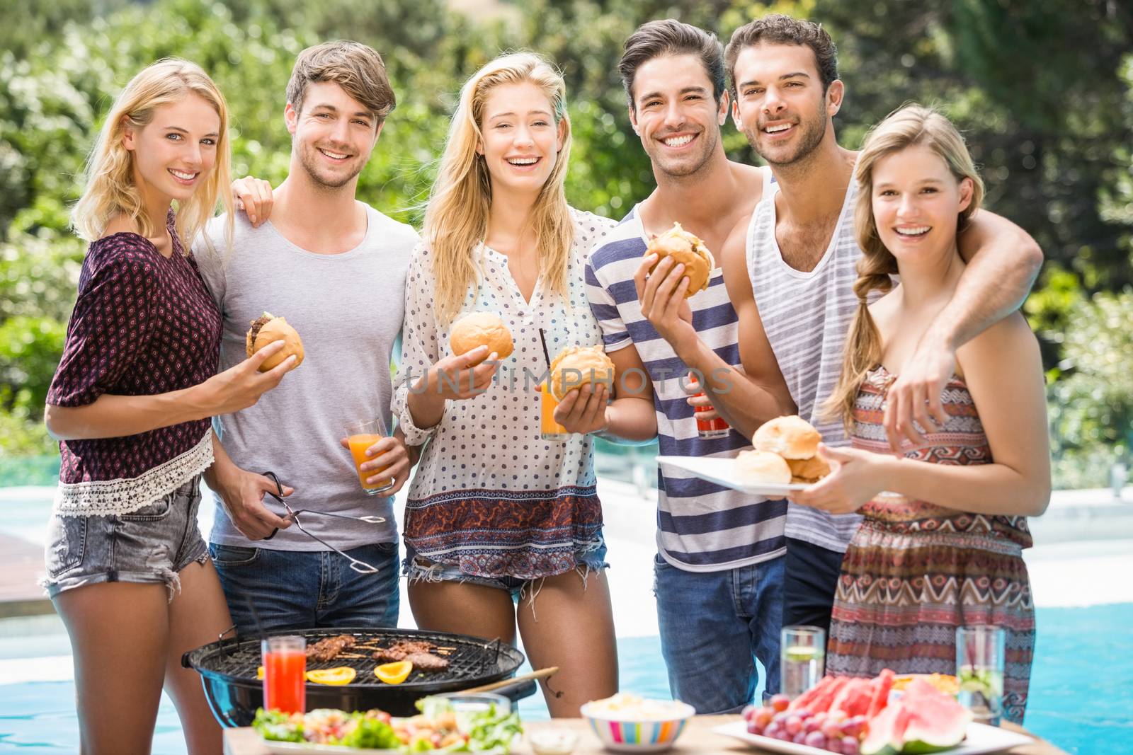 Group of friends having hamburgers and juice by Wavebreakmedia