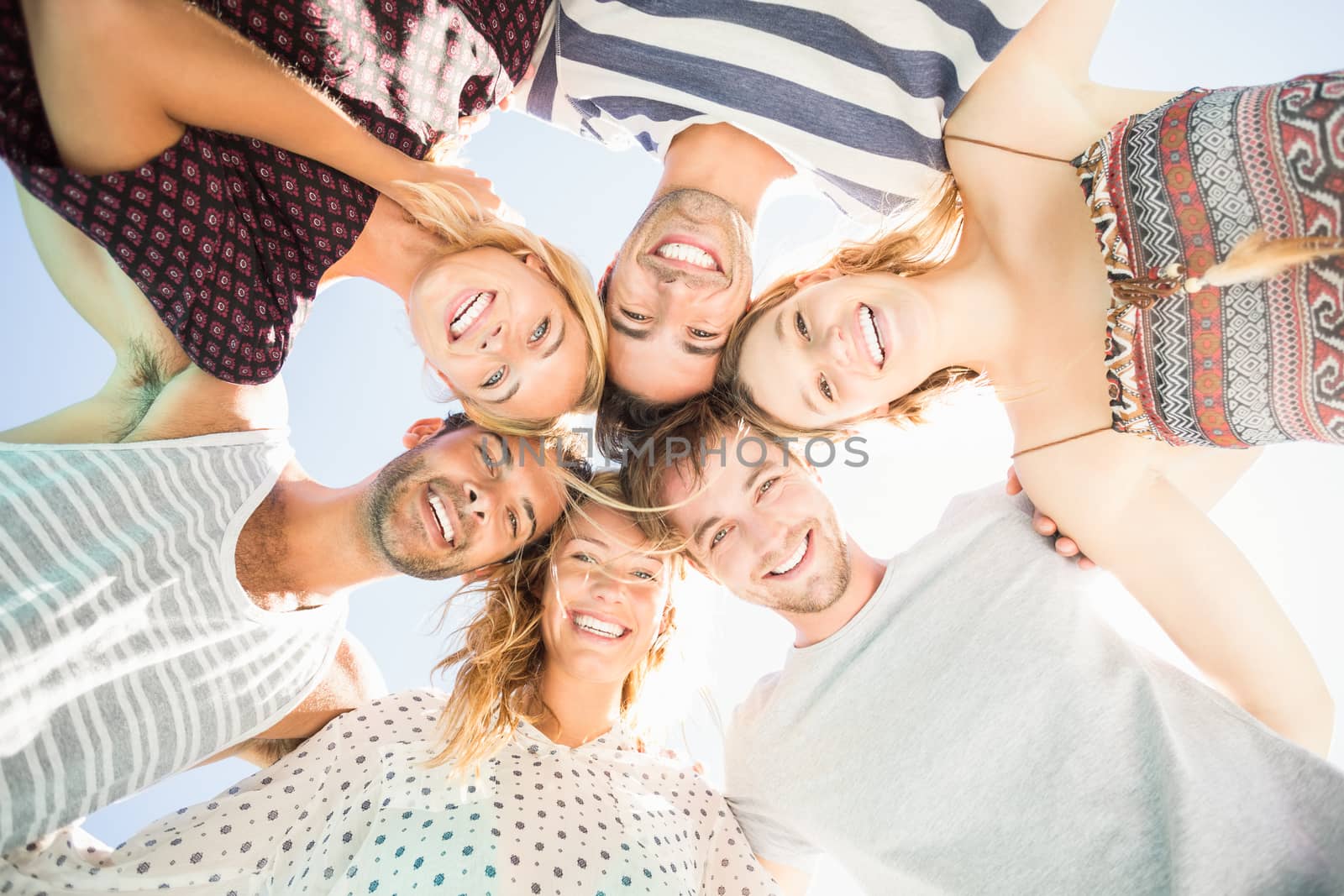 Group of friends forming a huddle by Wavebreakmedia