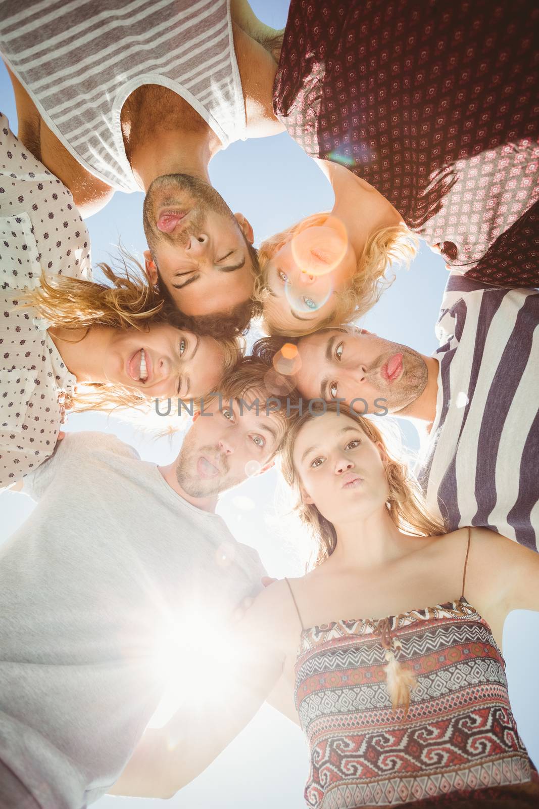 Group of friends forming a huddle by Wavebreakmedia