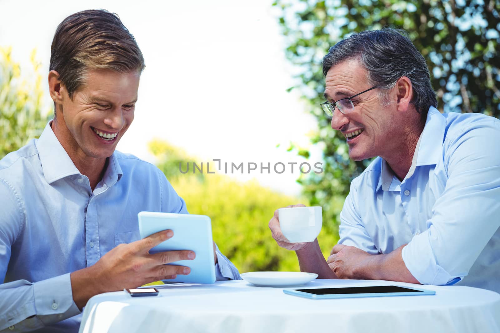 Two businessmen meeting in a restaurant using tablet by Wavebreakmedia