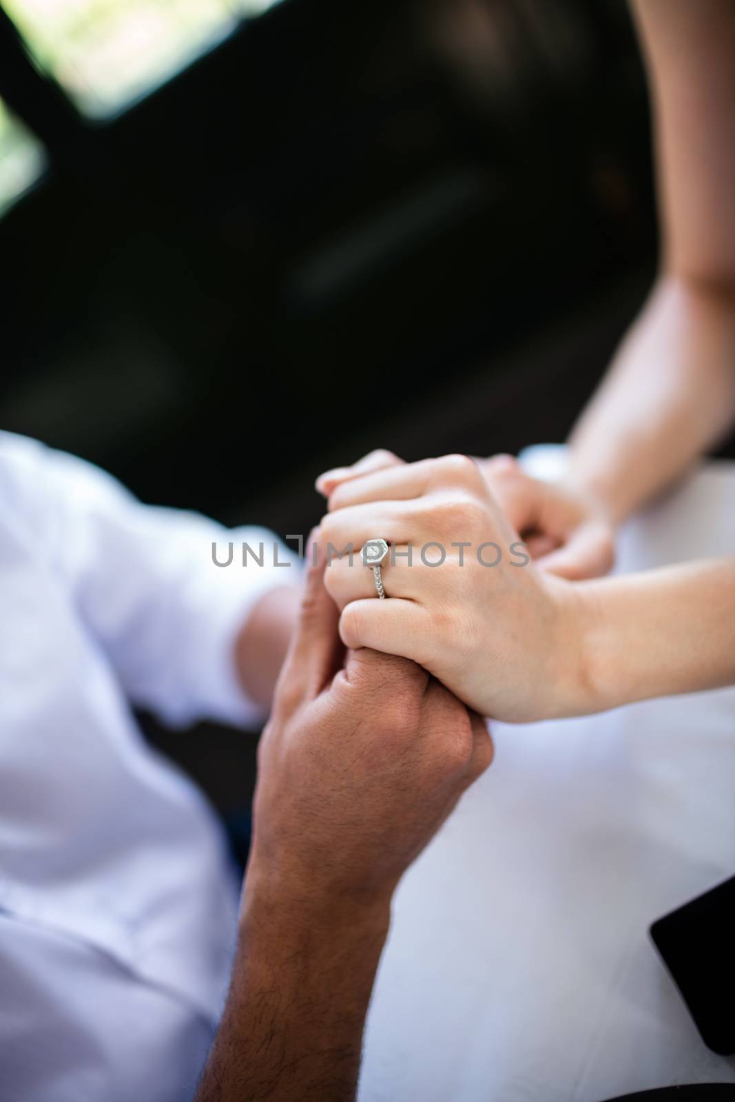 Close-up of couple holding hands with engagement ring by Wavebreakmedia