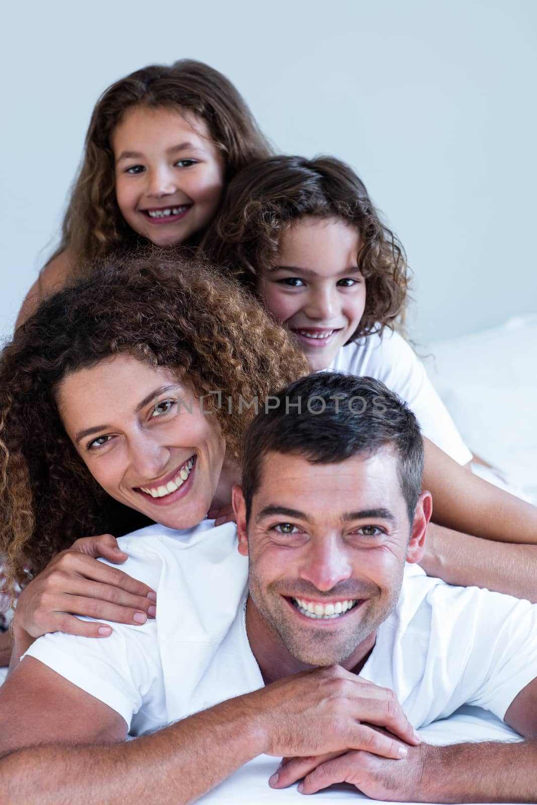Portrait of a family lying on top of each other by Wavebreakmedia