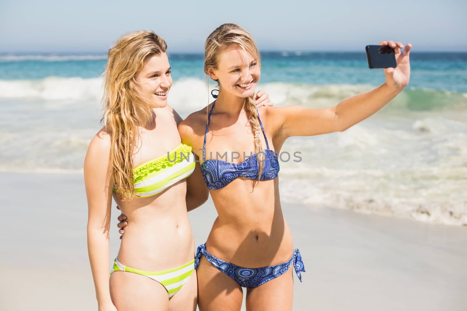 Two friends in bikini taking a selfie by Wavebreakmedia