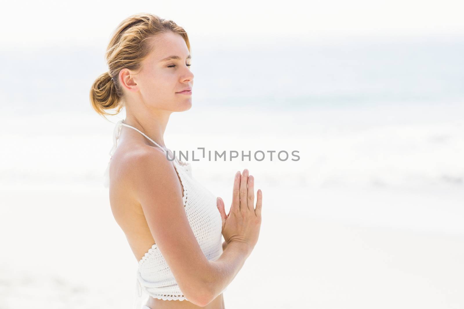 Beautiful woman in lotus position on the beach