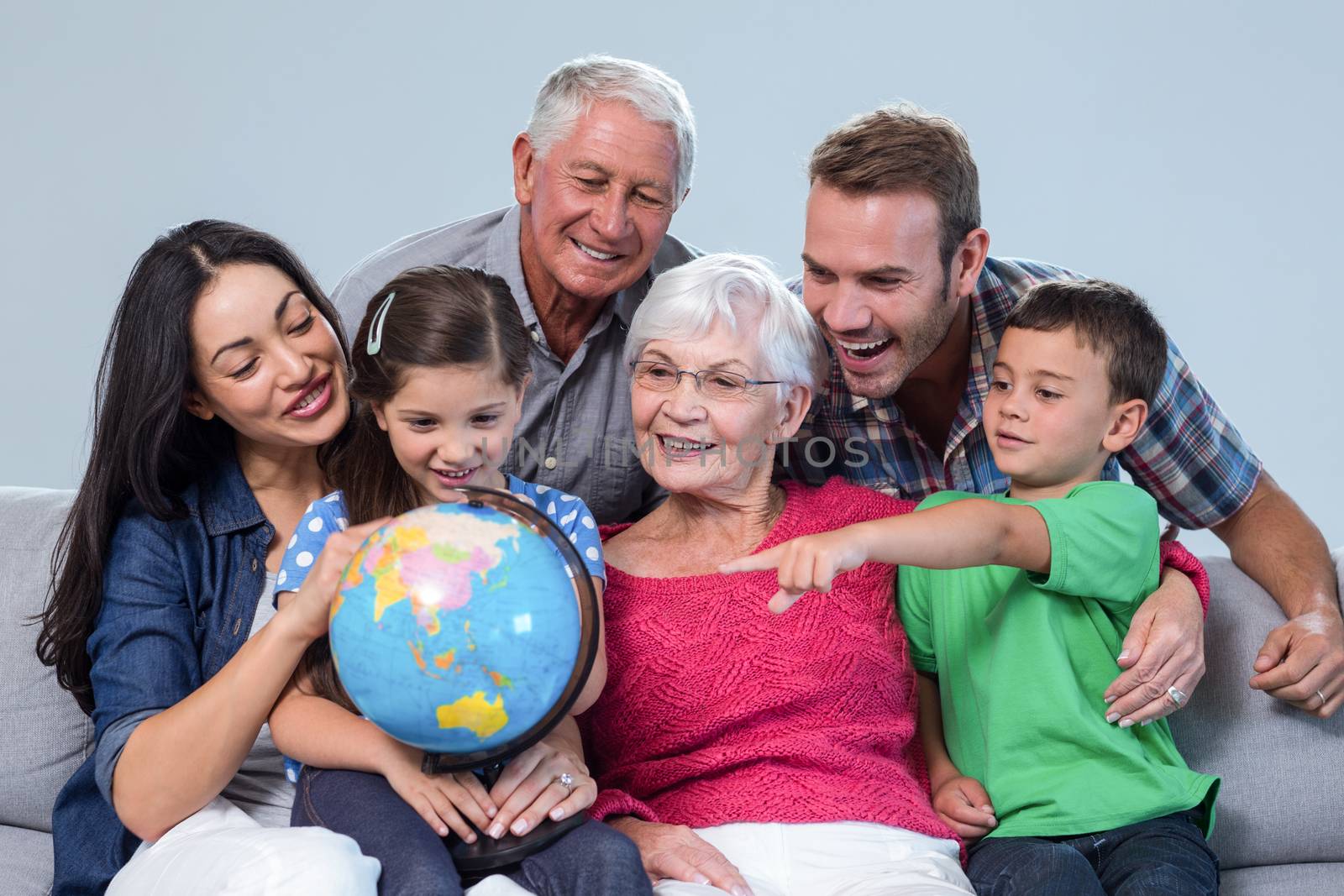 Happy family sitting on sofa holding a globe in living room